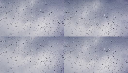 4K的原始视频雨滴落在窗户上，在灰色的天空下特写。高清在线视频素材下载