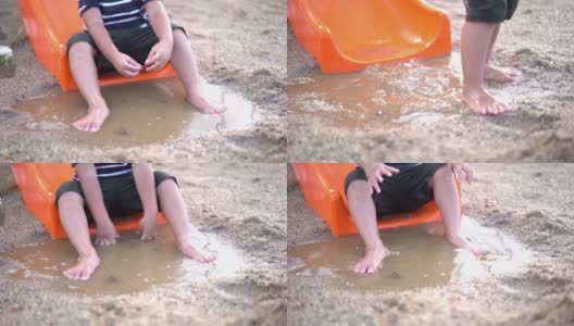 操场上，雨后坐在水坑里的可爱男孩高清在线视频素材下载