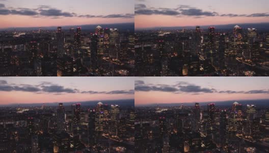 夜城的空中全景画面。高大的现代化办公大楼，日落后窗户有灯光。英国伦敦高清在线视频素材下载