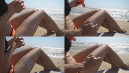 年轻女子坐在海滩上，在腿上涂上防晒油，防止晒伤高清在线视频素材下载