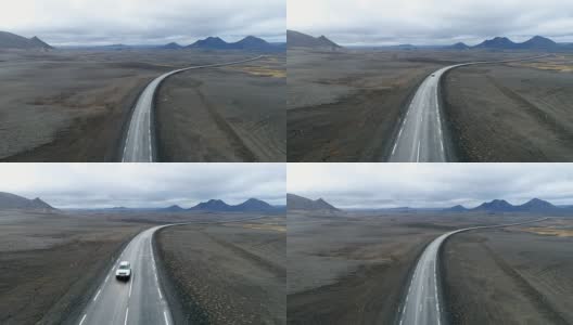 在火山沙漠中经过公路的汽车高清在线视频素材下载