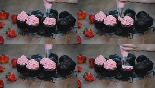 用草莓奶油装饰巧克力纸杯蛋糕。高清在线视频素材下载