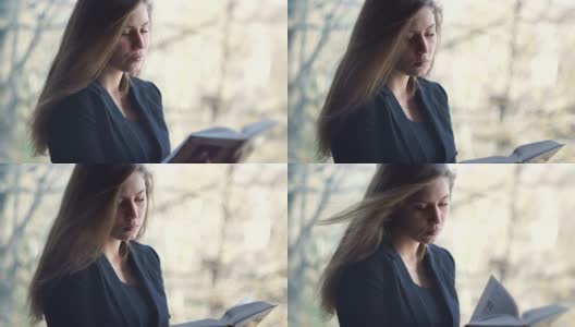 年轻，美丽的女孩读一本书-股票视频高清在线视频素材下载