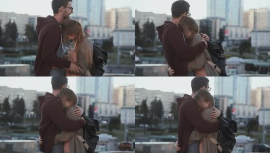 一对年轻英俊的夫妇站在市中心拥抱。快乐的男女正在进行浪漫的约会高清在线视频素材下载