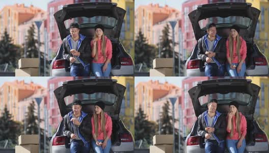 微笑的夫妇坐在后备箱的现代汽车高清在线视频素材下载