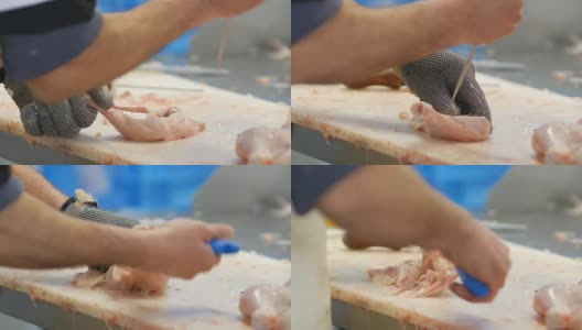 食品加工厂，鸡腿。男子手切肉的特写高清在线视频素材下载