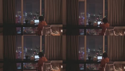 亚洲华人美丽的女人使用笔记本电脑工作，在家自习室书写耳机高清在线视频素材下载