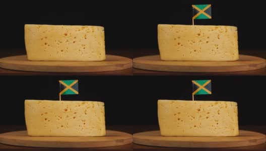 男人的手把一小块带有牙买加国旗的牙签放在奶酪上。高清在线视频素材下载