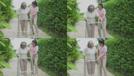亚洲的高级马瑟与沃克和成年的女儿在花园里散步。老妇残疾人步行和照顾年轻妇女帮助后院公园户外。保健家庭生活方式高清在线视频素材下载