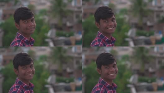一名印度少年的肖像，一边盯着镜头一边微笑。上学的青少年对着镜头微笑。积极情绪高清在线视频素材下载