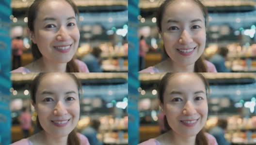 周末，一名亚洲女性在咖啡馆对着镜头微笑高清在线视频素材下载