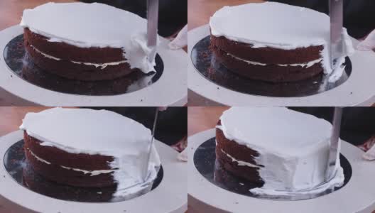 专业厨师的手是在海绵蛋糕的侧面涂上鲜奶油。高清在线视频素材下载