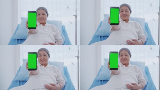 一位身患癌症的老年妇女坐在床上，正在用她的智能手机显示一些信息。高清在线视频素材下载