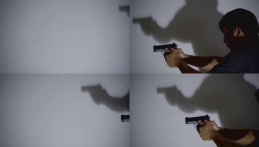 4K MS手持半自动手枪在晚上与白色墙壁上的阴影。高清在线视频素材下载
