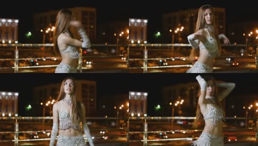 穿着东方民族服装的美丽年轻女子晚上在户外跳舞高清在线视频素材下载