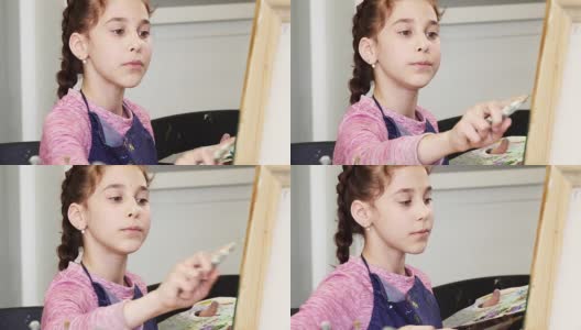 一个漂亮的小女孩拿着调色板画一幅画的特写高清在线视频素材下载