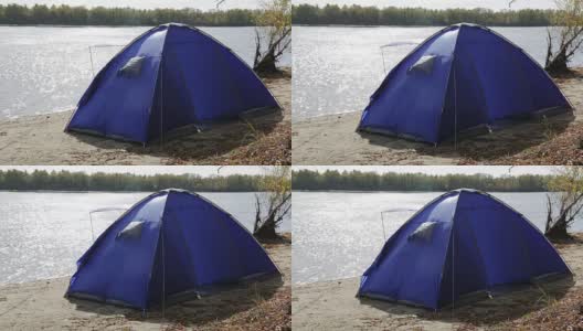秋天的河边，一个孤独的蓝色帐篷被一阵大风吹起高清在线视频素材下载