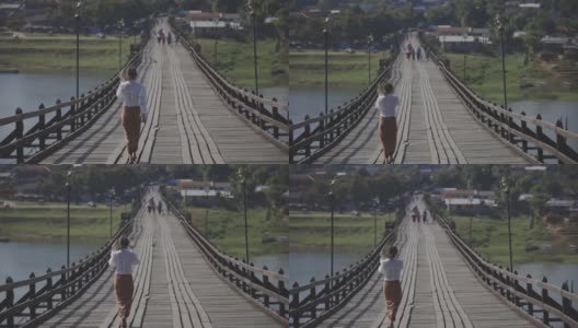 女人走在僧伽拉布里的桥上，北碧里美丽的日出高清在线视频素材下载