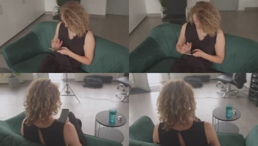 员工坐在沙发上，手里拿着手机。她打字短信经理高清在线视频素材下载