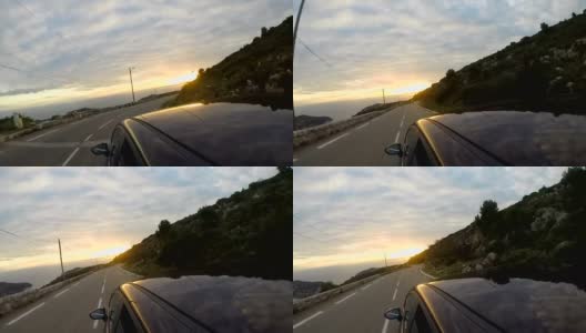 汽车在高速公路上朝着日落，海岸线在山脚下高清在线视频素材下载