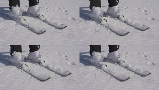 在一个阳光明媚的日子里，滑雪者踩进滑雪绑定与他的滑雪靴高清在线视频素材下载