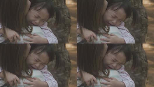 消极情绪亚洲母亲抱着哭泣的女婴在花园高清在线视频素材下载