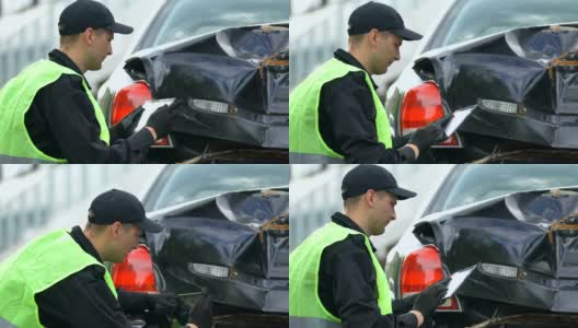 男性警察正在用平板电脑、在线应用程序对损坏的汽车拍照高清在线视频素材下载