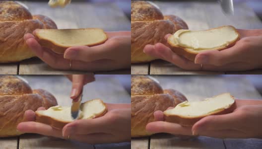 一位女性的手用一把刀在白面包上抹黄油。高清在线视频素材下载