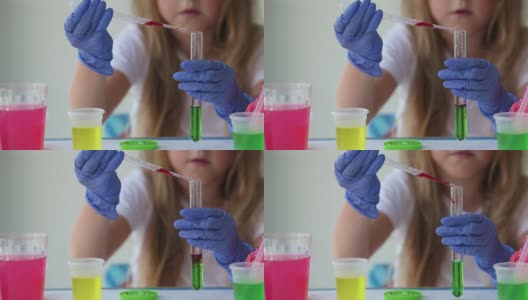 孩子做实验。在试管中连接不同颜色的液体。高清在线视频素材下载
