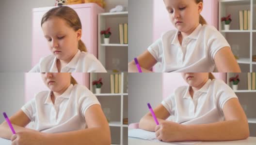 在家远程学习。这个女学生正在用电脑在线学习。一个学生坐在书桌前写笔记本。高清在线视频素材下载