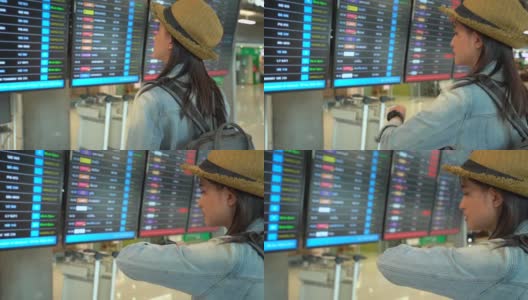 女旅客在机场候机楼查航班时刻表。高清在线视频素材下载