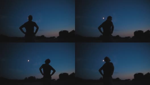 一个男人的剪影和乡村星空下年轻的月亮。高清在线视频素材下载