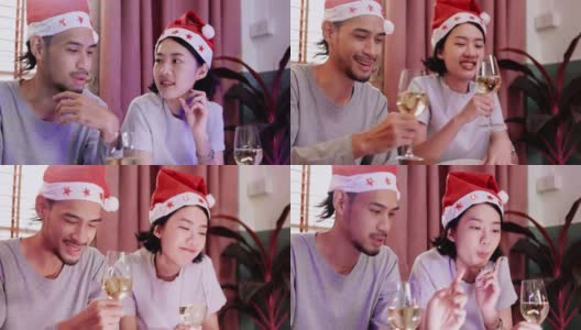 家庭年轻的亚洲夫妇坐在一起庆祝。在圣诞节与朋友视频通话，并在家里祝新年快乐。喝香槟，在平板电脑上在线看电影。通信技术高清在线视频素材下载