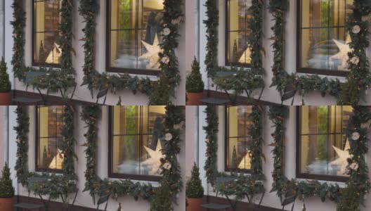 窗户上装饰着圣诞树、冷杉枝、装饰物和花环灯高清在线视频素材下载