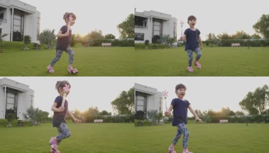 一个快乐微笑的小可爱或可爱的小女孩正拿着风车在草地上奔跑高清在线视频素材下载