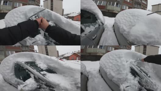 清理挡风玻璃——一名男子正在清理袭击他汽车的大雪，这张照片是用GoPro相机拍摄的高清在线视频素材下载