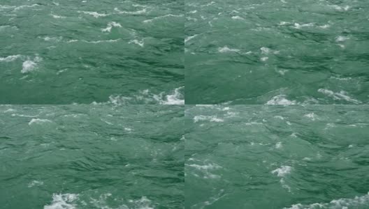 蓝色的冰川水从山上的河流流入大海的慢镜头，特写。高清在线视频素材下载