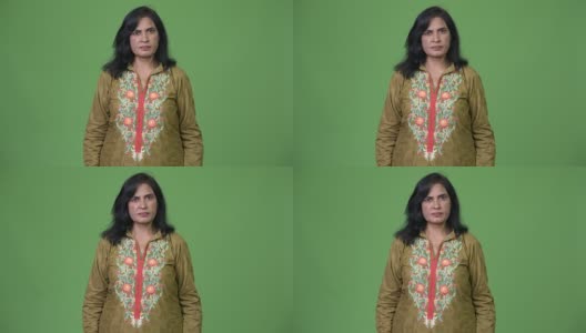 成熟美丽的印度妇女穿着传统服装在绿色的背景高清在线视频素材下载