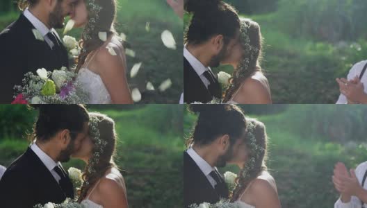 新娘和新郎接吻，在背景的客人抛花瓣4K 4K高清在线视频素材下载