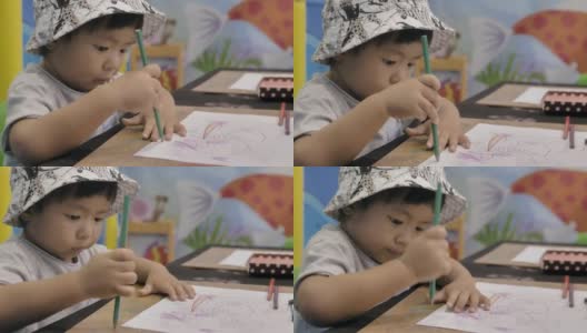 小男孩正在桌子上画画。高清在线视频素材下载