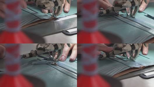 女性双手在缝纫机上把拉链整齐地缝到皮片上。概念生产皮具高清在线视频素材下载