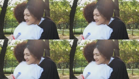 年轻的亚洲女学生戴着毕业帽和毕业礼服在大学，女性与毕业概念。怀着快乐的心情拥抱母亲的女人。高清在线视频素材下载