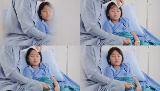 在医院的病床上，父亲坐在女儿旁边，一位年轻的男医生在探望他的小病人。医疗保健:照顾高清在线视频素材下载