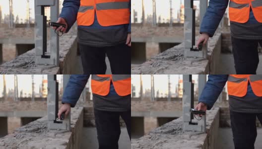 土木工程师用激光卷尺在高层建筑上测量高清在线视频素材下载