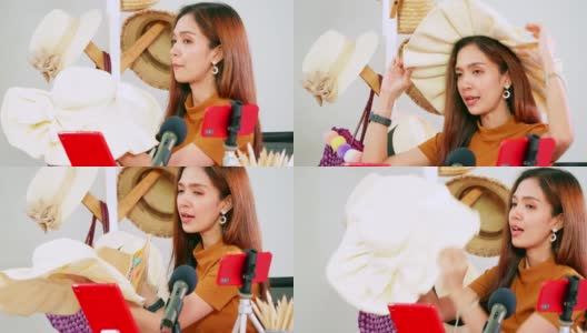 年轻的亚洲女孩在社交媒体上通过在家直播销售时尚帽子和包。高清在线视频素材下载