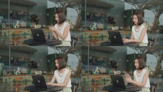 有思想的年轻女子正在努力工作，她的笔记本电脑在咖啡店高清在线视频素材下载