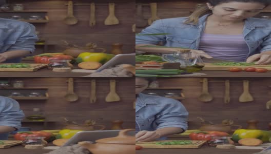 数码平板电脑食谱:多丽拍摄的西班牙年轻女子切菜准备食物高清在线视频素材下载