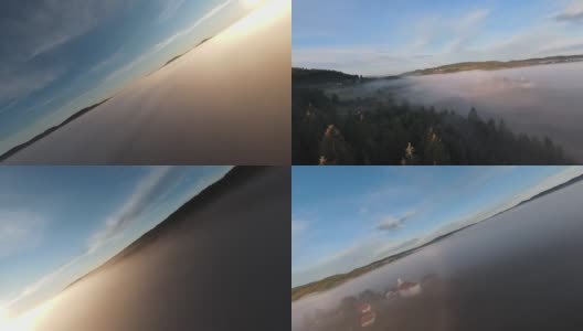 在晨雾中飞过薄雾的森林，在日出时，阳光照射在树梢。航拍在fpv无人机云朵自然景观与山地丘陵地形。电影的看法。高清在线视频素材下载