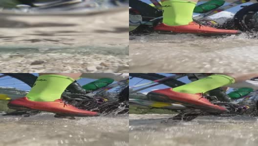 一个骑自行车的人穿过一条河的特写镜头高清在线视频素材下载