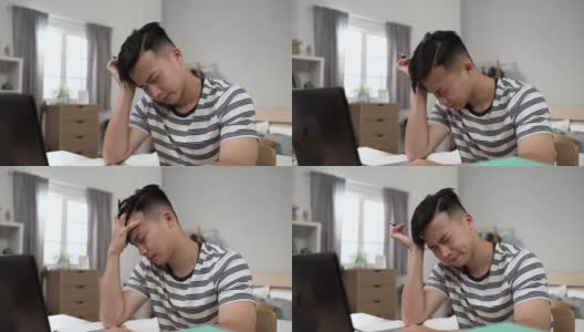 一名日本男学生白天在卧室的书桌上做作业时，因头痛而在家学习高清在线视频素材下载